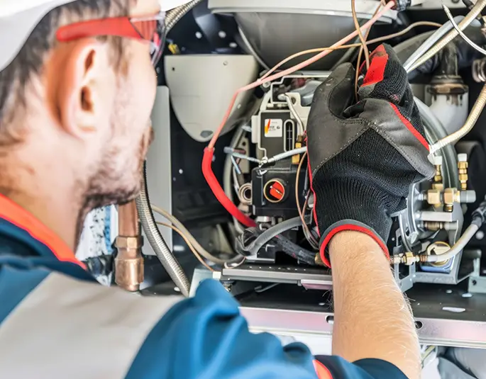 Technician working on furnace with safety gear and tools for maintenance springfield il