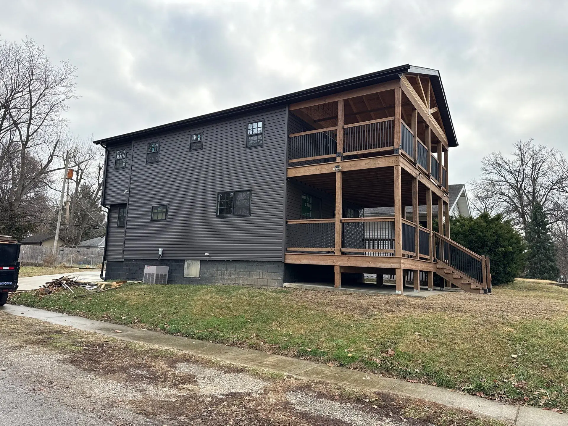 Rear exterior view of a completed residential renovation with covered decks in Springfield, IL.