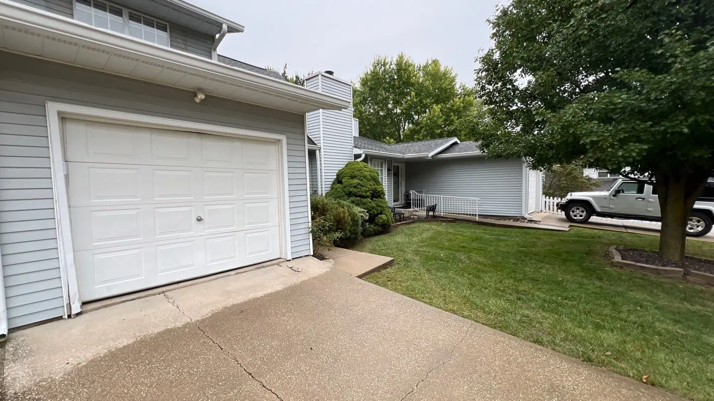 Garage and front exterior before siding replacement on townhouse in Springfield, IL