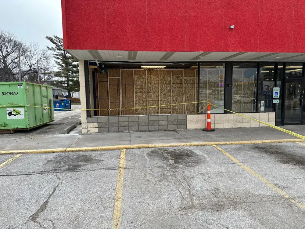 Retail storefront under structural renovation with temporary safety barriers in Moline, IL