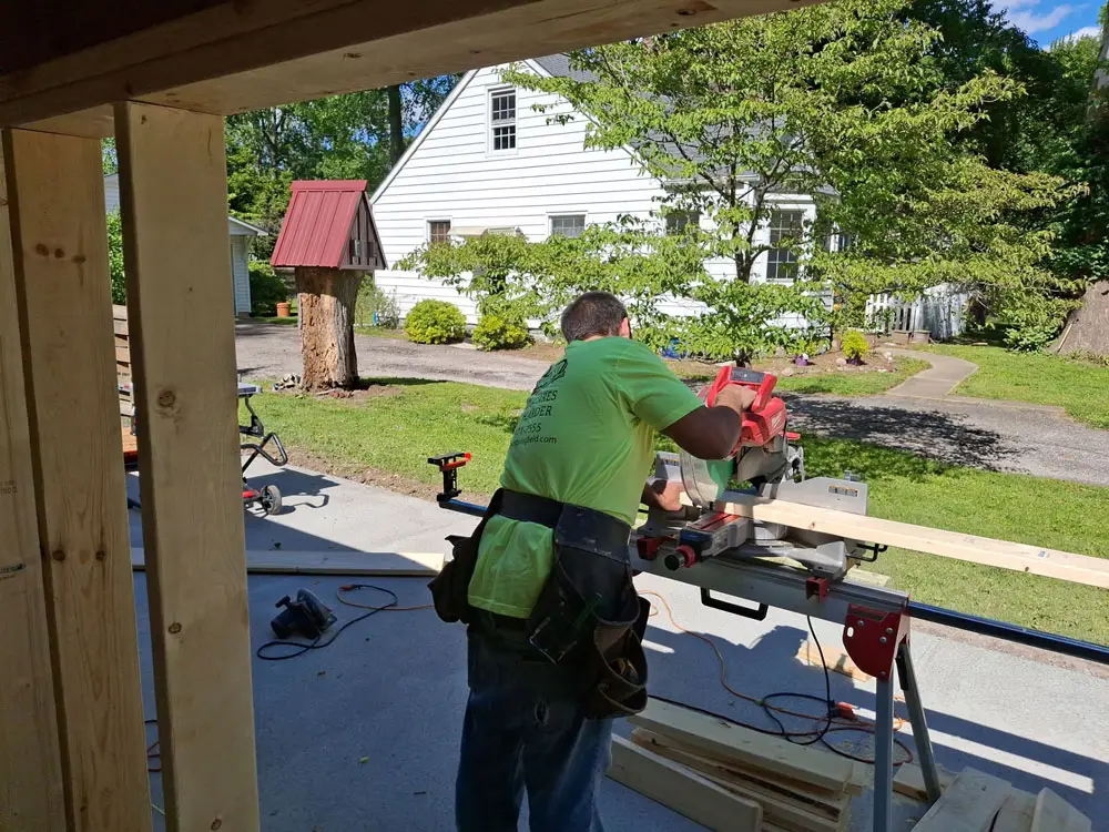 Contractor cutting lumber during residential home addition framing project in Springfield, IL